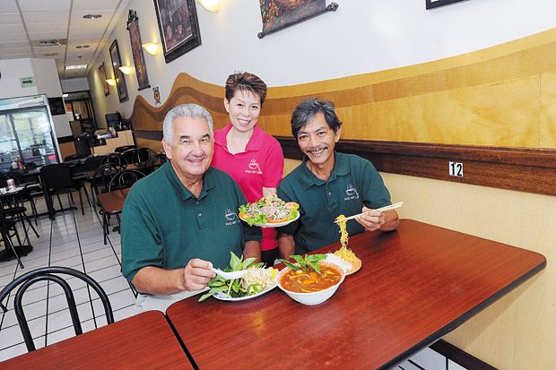 Feasting on a few favorites — Lemon Beef Salad and the restaurant's newest menu item, Beef Stew — are, from left, fi nancial adviser Walter James and co-owners Lien Bui and Tommy Dang. 