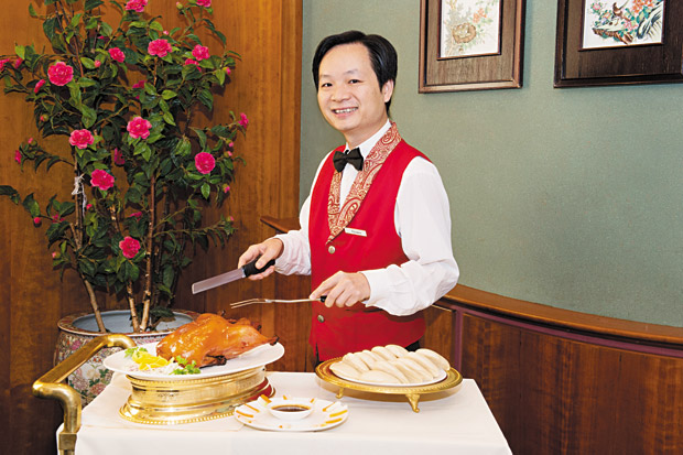 Waiter San Wang gets ready to carve Peking Duck. 