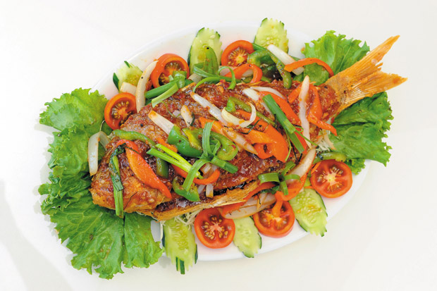 Whole Fish (market price) from Thai Lao featuring fresh snapper and covered with chili sauce and vegetable seasonings.  