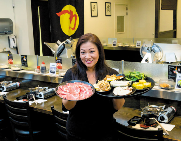 General manager Nadine "Dee Dee" Yoshishige-Doi with an assortment of meat and appetizers from the all-you-can-eat lunch and dinner menu 